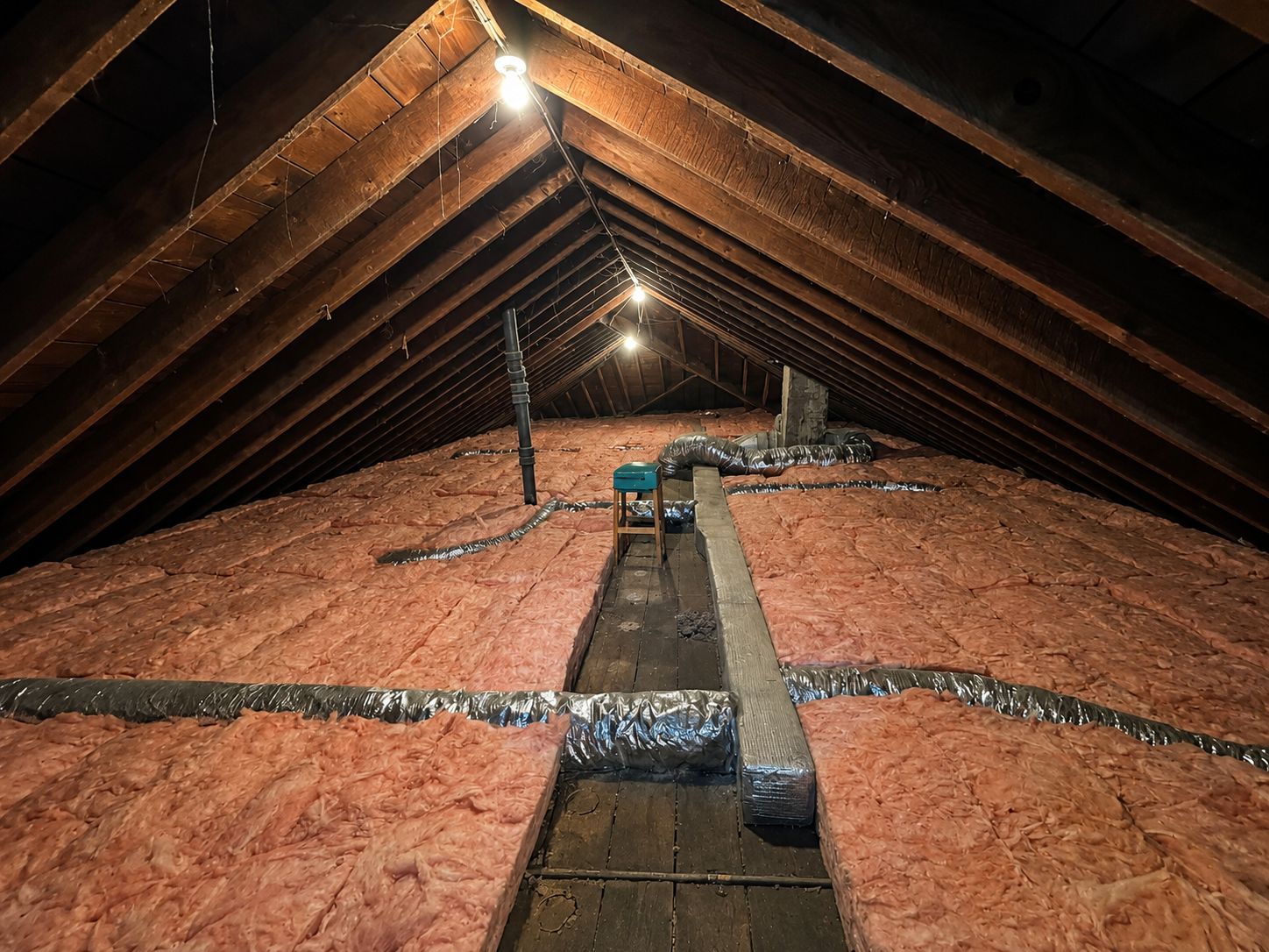Attic fully insulated by Souzet with wrapped ductwork running the length of the ridge